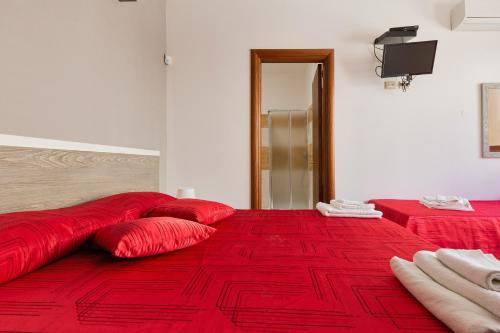 a large red bed with red pillows on it at Lido Marini Rooms Affittacamere B&B in Lido Marini