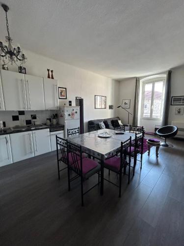 une cuisine et une salle à manger avec une table et des chaises dans l'établissement Appartement spacieux en Provence, à Châteaurenard
