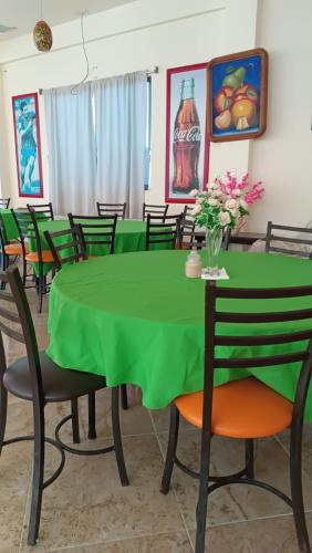 a dining room with a green table and chairs at Casa O K in Tecolutla