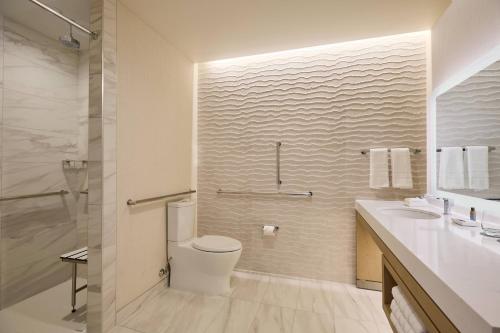 a white bathroom with a toilet and a sink at The Westin Raleigh-Durham Airport in Raleigh