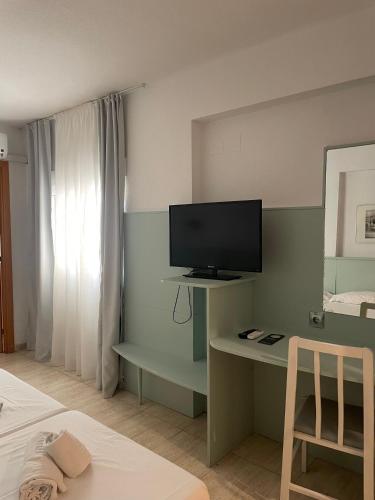 a bedroom with a desk with a television and a bed at Fleming Center by Punta 25 Hotels Group in Benidorm