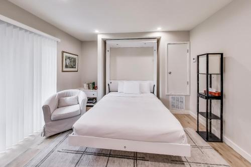 een witte slaapkamer met een bed en een stoel bij Cozy Marina Studio w Murphy Bed & Garden Oasis in San Francisco