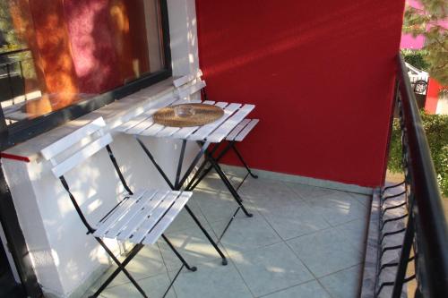 un tavolo bianco e due sedie su un portico di Hotel Color a Asenovgrad