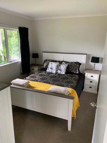 a bedroom with a bed and a window at Incline Cottage in Upper Hutt