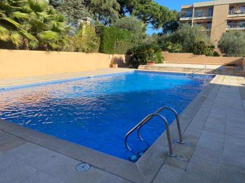 une grande piscine bleue avec une main courante dans l'établissement Lovely studio apartment, à Nice