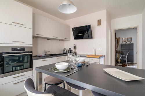 - une cuisine avec une table, des chaises et un comptoir dans l'établissement Charmille - Un havre de paix, à Strasbourg