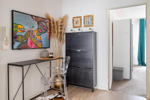 Cette chambre comprend un bureau et une armoire noire. dans l'établissement Charmille - Un havre de paix, à Strasbourg