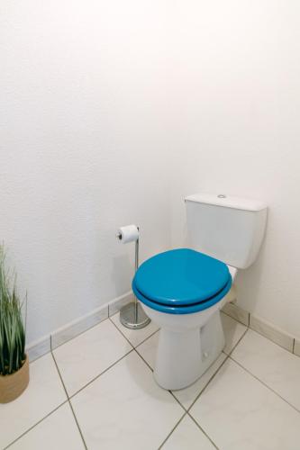 La salle de bains est pourvue de toilettes avec un siège bleu. dans l'établissement T2 tout confort Quartier Bourran Jardin - Parking - Piscine, à Rodez