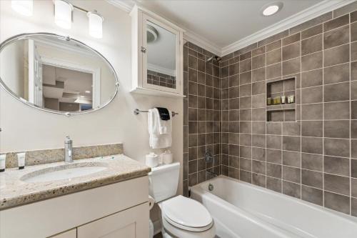 a bathroom with a toilet and a sink and a mirror at 308 W Taylor Street Garden in Savannah