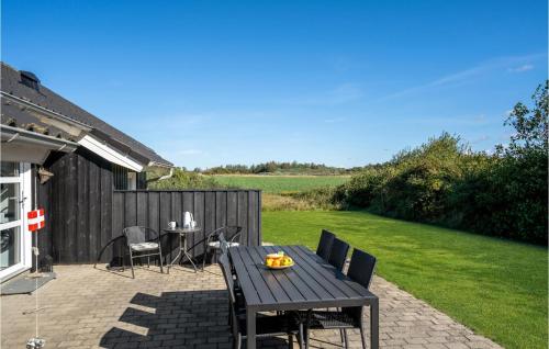 a wooden table and chairs on a patio at Holiday Home Toftevej Løkken V in Løkken