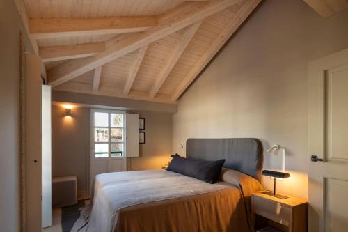 a bedroom with a large bed with a wooden ceiling at Casa Juanita in Melide