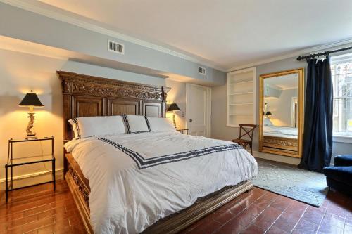 Un dormitorio con una cama grande y un espejo. en 17 E Jones Garden, en Savannah