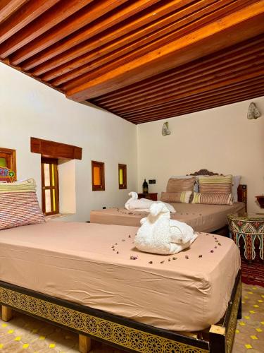 a bedroom with two beds in a room at Riad Hamad Tijani in Fès