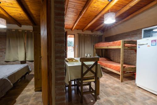 a room with a table and two bunk beds at Cabañas San José de Pemehué in San Rafael