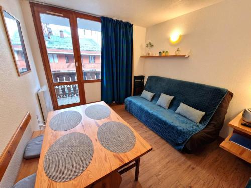 un salon avec un canapé bleu et une table dans l'établissement Studio central pour 3 pers., proche pistes - FR-1-265-359, à Modane