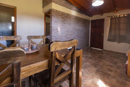 a dining room with a wooden table and chairs at Cabañas San José de Pemehué in San Rafael
