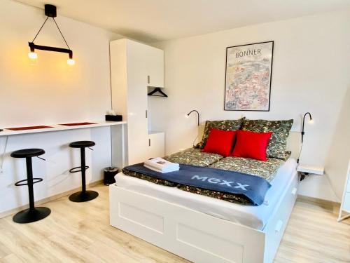 a room with a bed with red pillows on it at Zuhause auf Zeit-Gemütliche Gästezimmer in Bonn