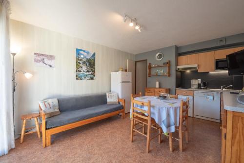 un salon avec un canapé et une table et une cuisine dans l'établissement Le Village des Thermes, à Vignec