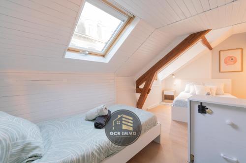 une chambre mansardée avec un lit et une fenêtre dans l'établissement Style indus & Billard - Coeur de Grenoble, à Grenoble