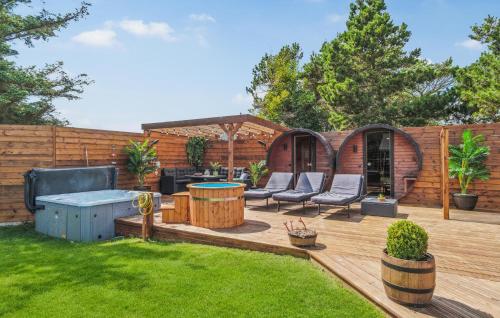 a patio with chairs and a table in a yard at Lovely Home In Thisted With Sauna in Thisted