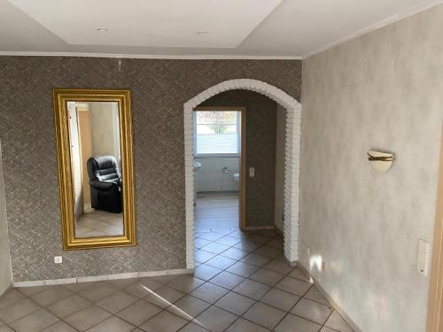 a hallway with a mirror and a black chair at Ferienwohnung Hammesdammer-Land in Lastrup