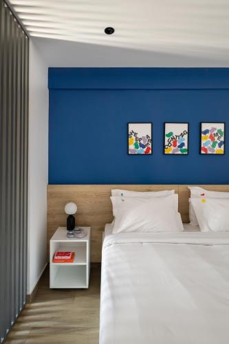 a bedroom with a blue accent wall and a bed at Fits Living in Athens