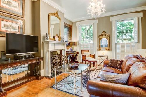 a living room with a couch and a tv at 17 E Jones Street Parlor in Savannah