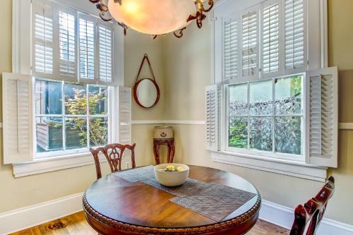 a dining room with a table and chairs and windows at 17 E Jones Street Parlor in Savannah