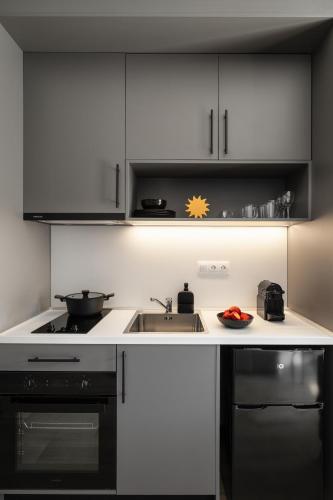 a kitchen with a sink and a stove at Fits Living in Athens