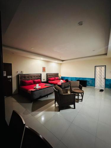 a living room with a red couch and chairs at Maxwell inn in Taiping