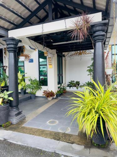 a building with columns and potted plants in front of it at Maxwell inn in Taiping