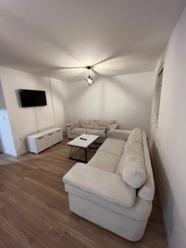 a living room with a white couch and a table at Apartman Perla in Pale