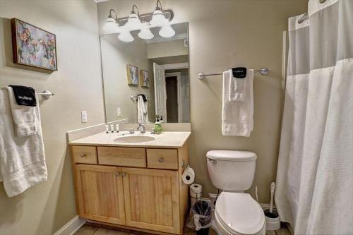 a bathroom with a toilet and a sink and a mirror at 305 W Taylor Garden in Savannah