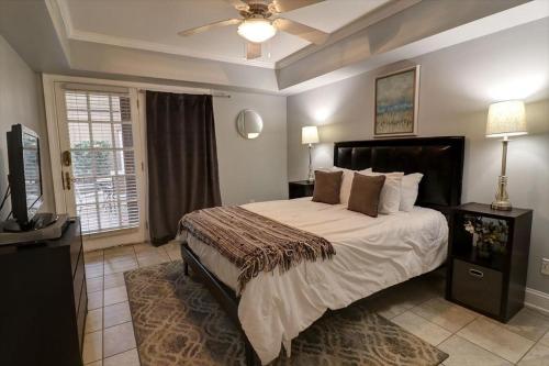 a bedroom with a large bed with a ceiling fan at 305 W Taylor Garden in Savannah