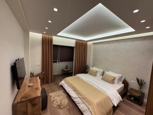 a bedroom with a large bed and a table at R&DLux in Durrës