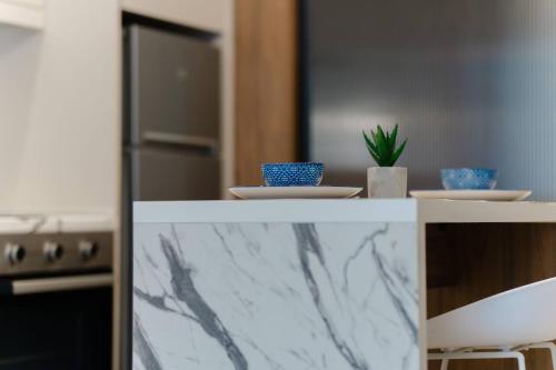 a kitchen with a marble counter top with bowls and a plant at R&b Living Experience in Alexandroupoli
