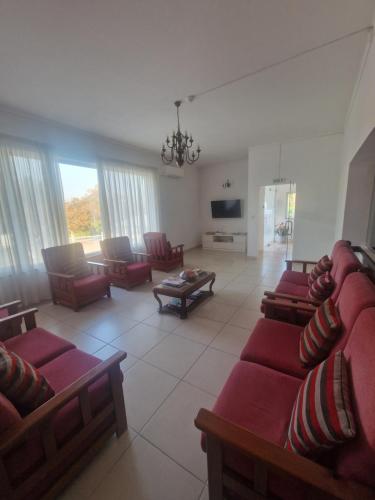 a living room with red couches and a tv at Hotel Padre Cruz in Valença