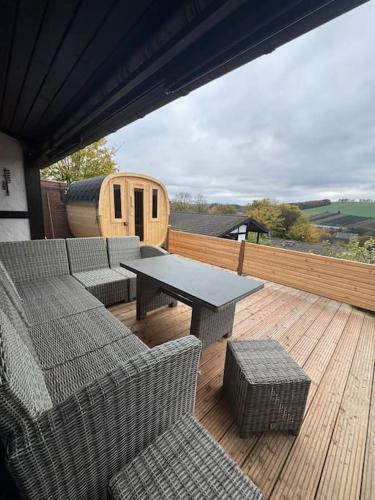 a patio with a table and chairs on a deck at Ferienhaus Henneglück3 mit Sauna in Meschede