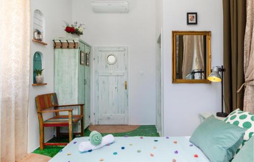 a bedroom with a bed and a chair and a mirror at Nice Home In Vis With Kitchen in Vis