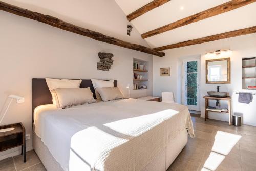 une chambre avec un grand lit blanc dans une pièce dans l'établissement Maison de charme entre mer, plages et montagne, à San-Giuliano