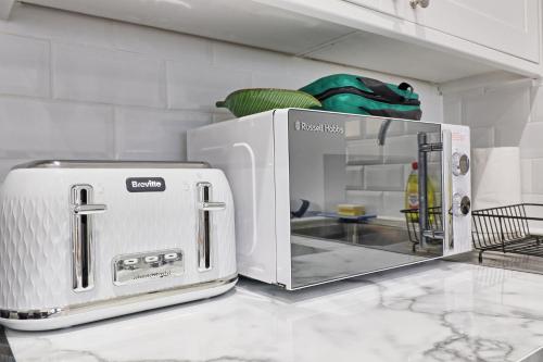 a white toaster oven sitting on top of a counter at Chelmsford City Central Ground Floor Apartment Next To Town Centre in Chelmsford