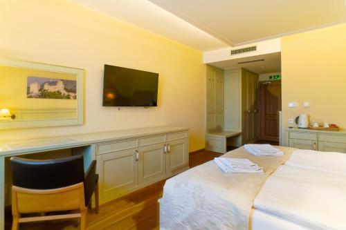 a bedroom with two beds and a flat screen tv at Vinařství Peřina in Klentnice