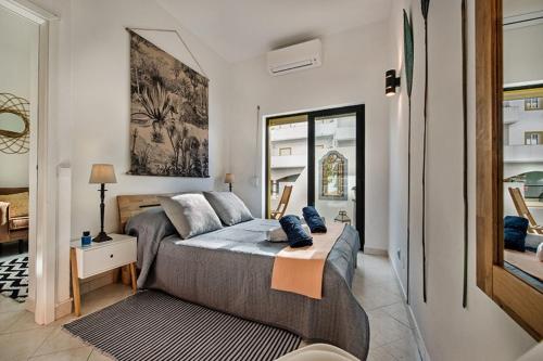 a bedroom with a bed and a mirror at 212 Aurora sol - CASINHA DO SOL in Praia do Carvoeiro