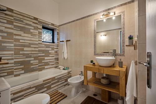 a bathroom with a sink and a tub and a toilet at 212 Aurora sol - CASINHA DO SOL in Praia do Carvoeiro