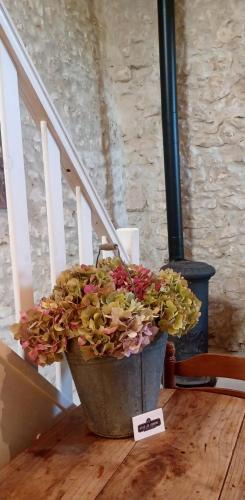 a pot of flowers sitting on a wooden table at Gites les Lignons in Champniers