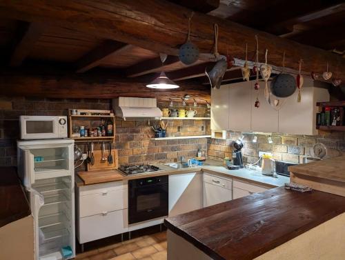 une cuisine avec des armoires blanches et un four à plaques de cuisson dans l'établissement Châlet Les Arcs 1600- Montrigon Funiculaire, à Bourg-Saint-Maurice