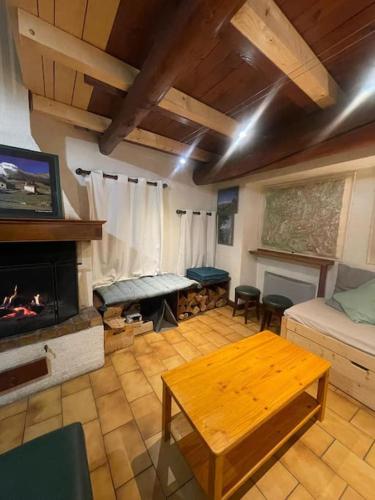 un salon avec une table et une cheminée dans l'établissement Châlet Les Arcs 1600- Montrigon Funiculaire, à Bourg-Saint-Maurice