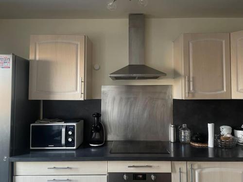 une cuisine avec des armoires blanches et un micro-ondes dans l'établissement Double room in a shared duplex flat 15 mins from La Defense Arena - Business Center, à Nanterre