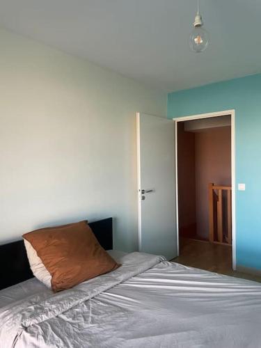 une chambre avec un lit avec un oreiller dessus dans l'établissement Double room in a shared duplex flat 15 mins from La Defense Arena - Business Center, à Nanterre