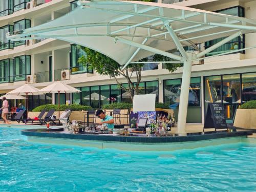 a poolside bar with an umbrella in the water at 2 BDR Suite in 5 Star Hotel in Rawai Beach